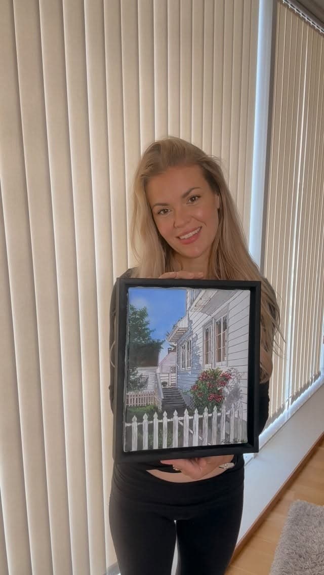 Portrett av kunstneren foran lyse gardiner.